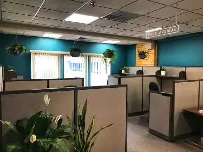Open coworking floor at FreeportWerkes with dedicated desks, plants, and a Park Avenue sign